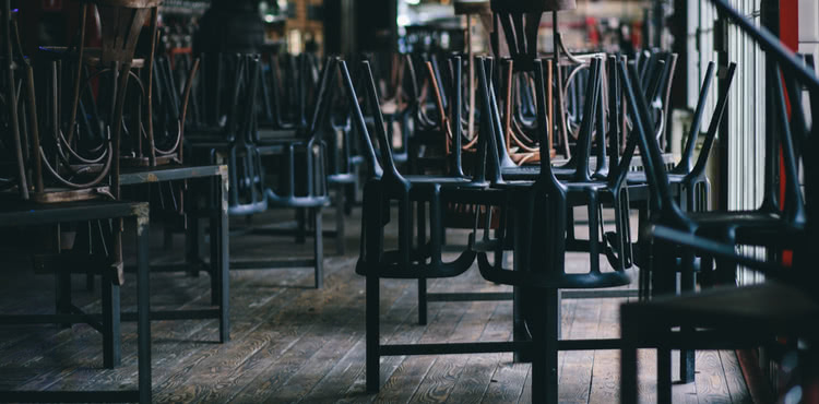 Closed restaurant with chairs stacked on tables Closed restaurant with chairs stacked on tables