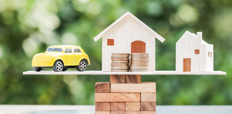 Image of a house and car balanced between a stack of coins to represent savings Image of a house and car balanced between a stack of coins to represent savings