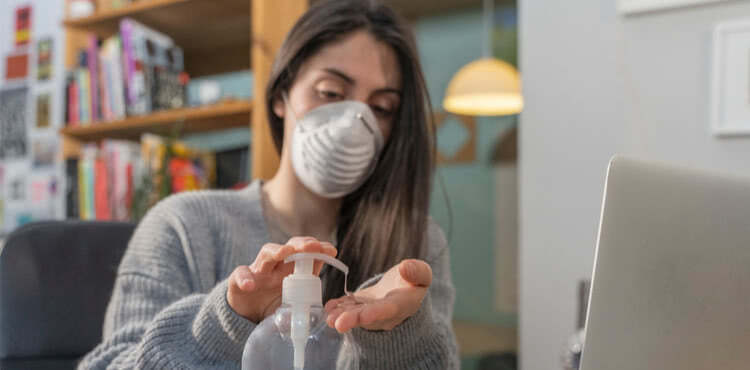Woman at home sanitizing hands Woman at home sanitizing hands