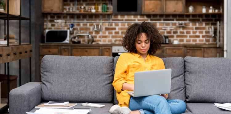 Young woman on couch working on a laptop Young woman on couch working on a laptop