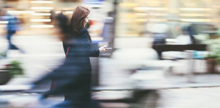 Woman in motion checking phone on street. Woman in motion checking phone on street.