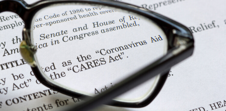 Reading glasses resting on top of a copy of the CARES COVID relief act. Reading glasses resting on top of a copy of the CARES COVID relief act.