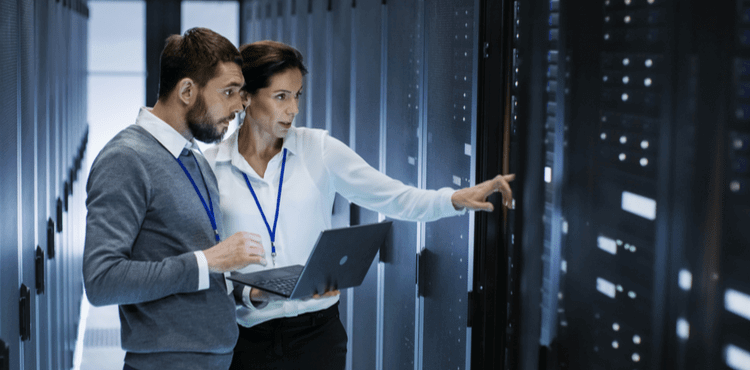 IT consultant conferring with client in server room. IT consultant conferring with client in server room.