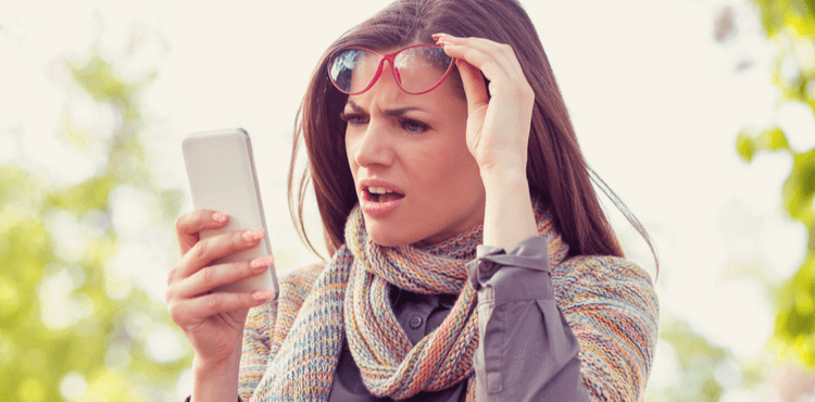Shocked woman reading defamatory social post on phone.