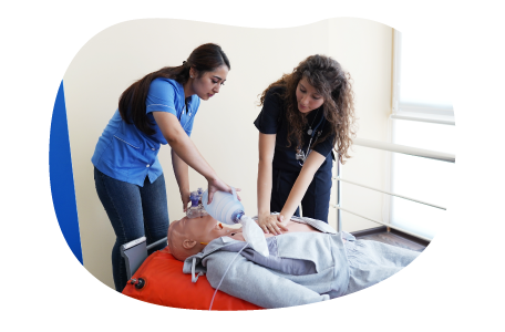 A nurse educator trains a student using a CPR manikin.