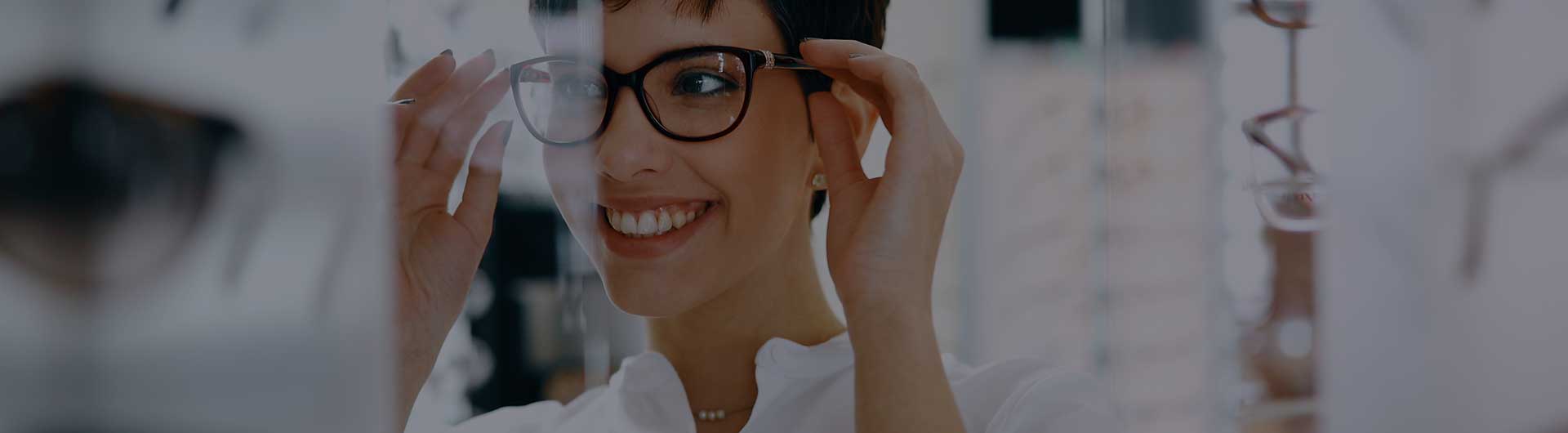 Woman with optician trying eyeglasses.