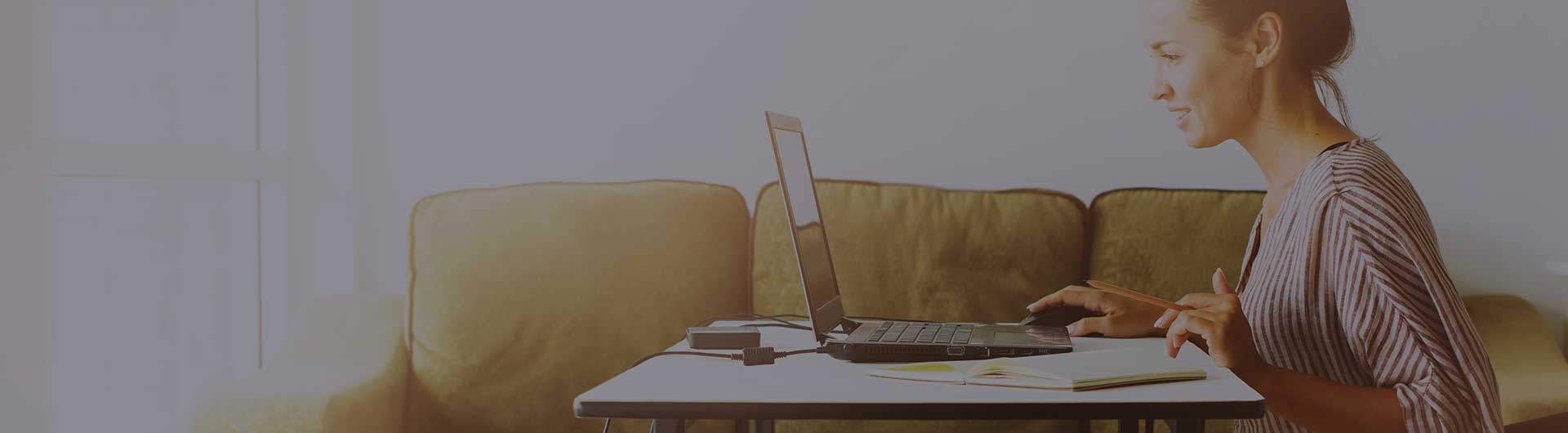 Person working on a low table by a couch.