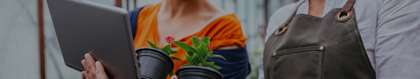 The owner of a garden center and an employee working on a tablet.