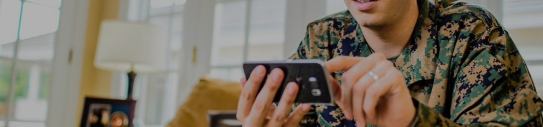 A military officer compares insurance quotes on their smartphone. A military officer compares insurance quotes on their smartphone.