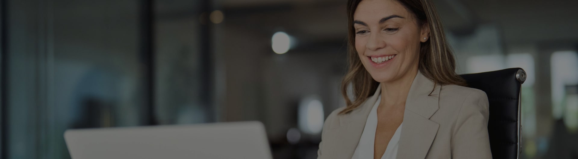 Small business owner researching frequently asked insurance questions on laptop.