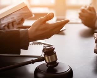 A group of lawyers consulting behind a gavel.