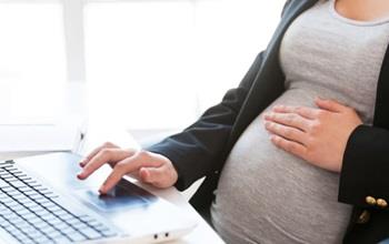 Pregnant woman at her desk.