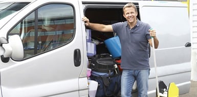 Person stands by a van full of cleaning supplies.