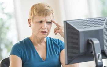 Woman at computer looking confused.