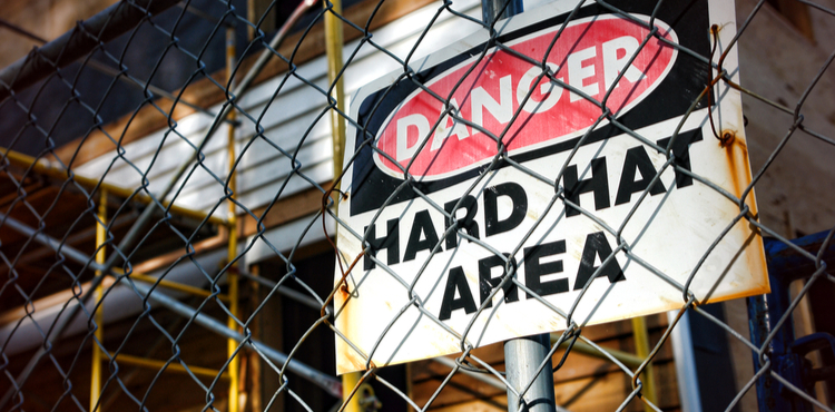Photo of a danger sign behind a chainlink fence.