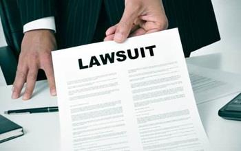 Man in suit hands over notice of lawsuit.