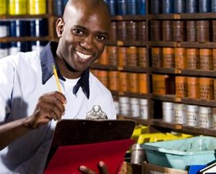 Man with a clipboard doing inventory in a stock room.