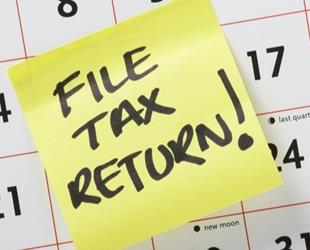 Post it reminder on calendar to file a tax return.