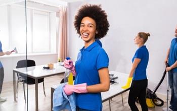 A team of janitors cleans an office space.