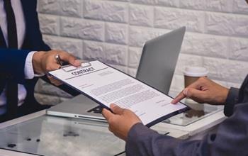 Two business men discuss and sign contract.