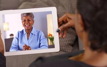 Two women have a video call on a tablet.