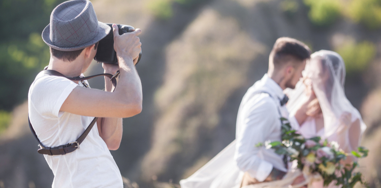 Wedding photographer shooting photo of bride and groom.