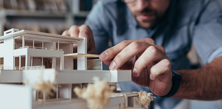 An architect builds a wooden building model.