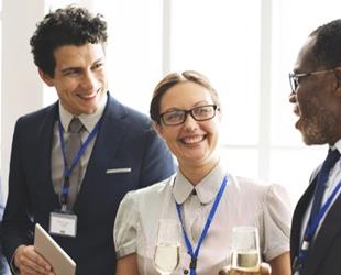 A group of people converse at a work event.