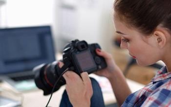 A photographer reviews the photographs on her camera.