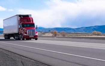 A red semi truck cruises down a highway in Utah.