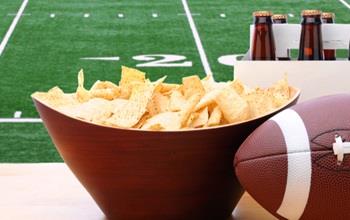 Bowl of chips and a six pack of beer, ready for a football party.