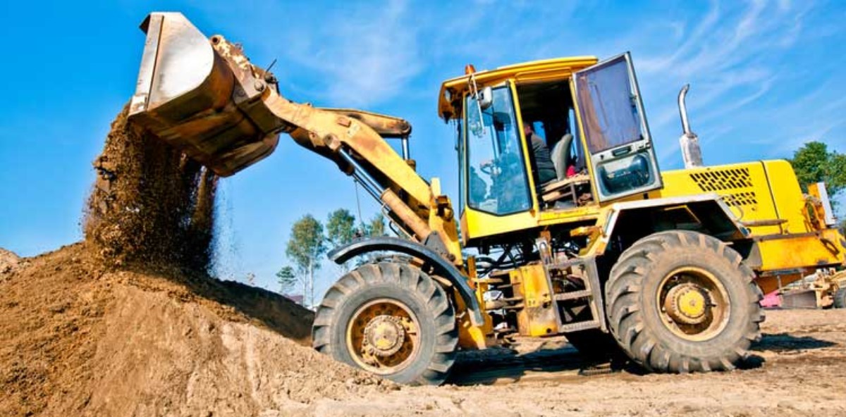 A front loader moves dirt on a construction site.