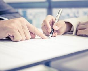 Closeup of hands signing a contract.