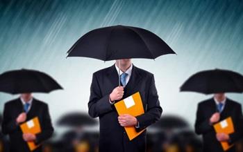 Businessmen carrying umbrellas during a storm