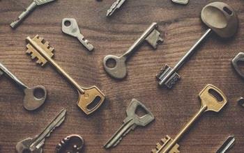 Keys placed on a wooden table in a pattern.