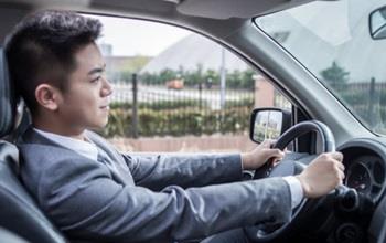 Man in a sport coat driving