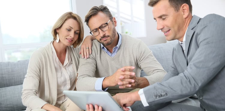 Three people reviewing information on a tablet