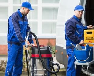 Two janitors with cleaning equipment