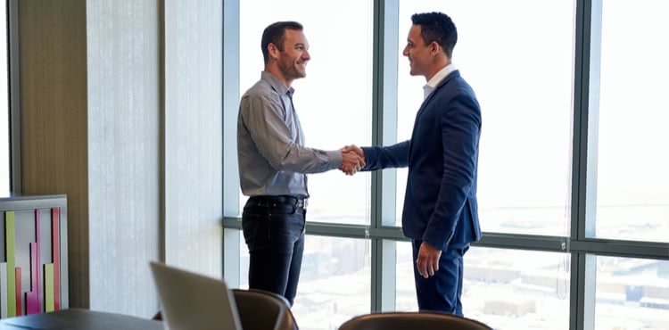 Two men shaking hands in an office Two men shaking hands in an office