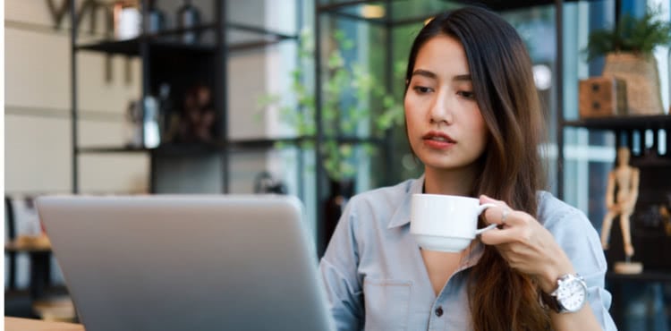 Woman with a laptop drinking coffee