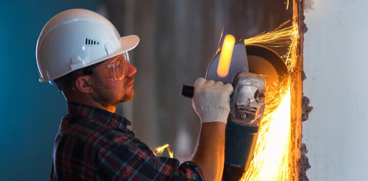 Construction worker using a grinder