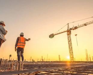 Two construction workers surveying a job site