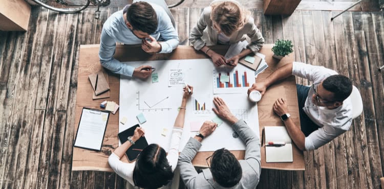 Five people working together at a table.