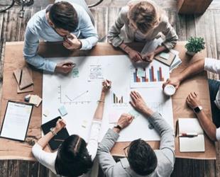 Five people working together at a table.