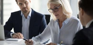 A serious woman signing paperwork