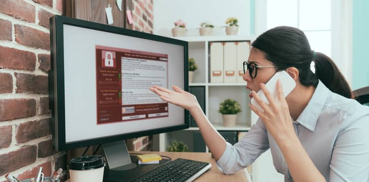 Upset woman on phone viewing locked computer screen