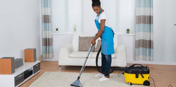 Young woman cleaning a carpet