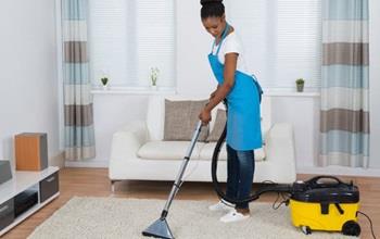 Young woman cleaning a carpet