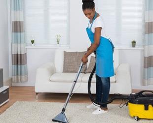 Young woman cleaning a carpet