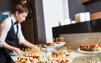 A caterer setting up a table of food at an event